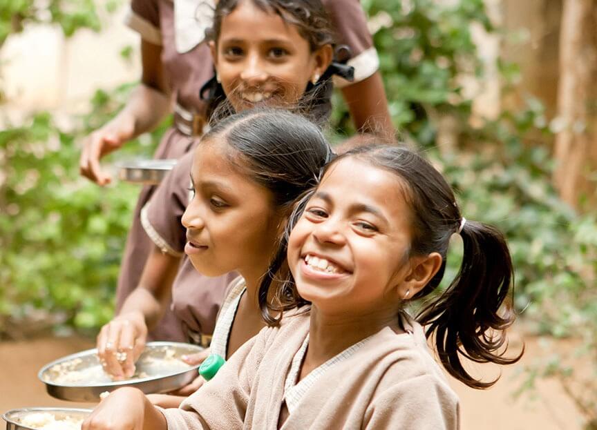 Smiling happy school kids having mid day meal
